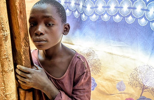A Ugandan boy listens to a broadcast about the evils of child sacrifice