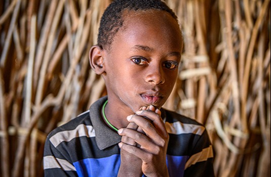Ten-year-old Peter of Turkana, Kenya, looks into the camera with a serious expression.
