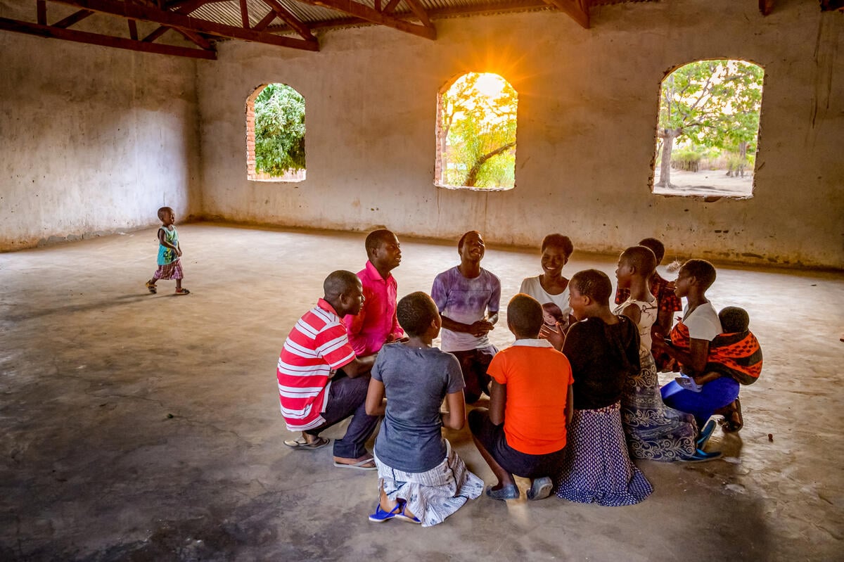 A group of young people are sitting in a church in Malawi and rehearsing songs. 