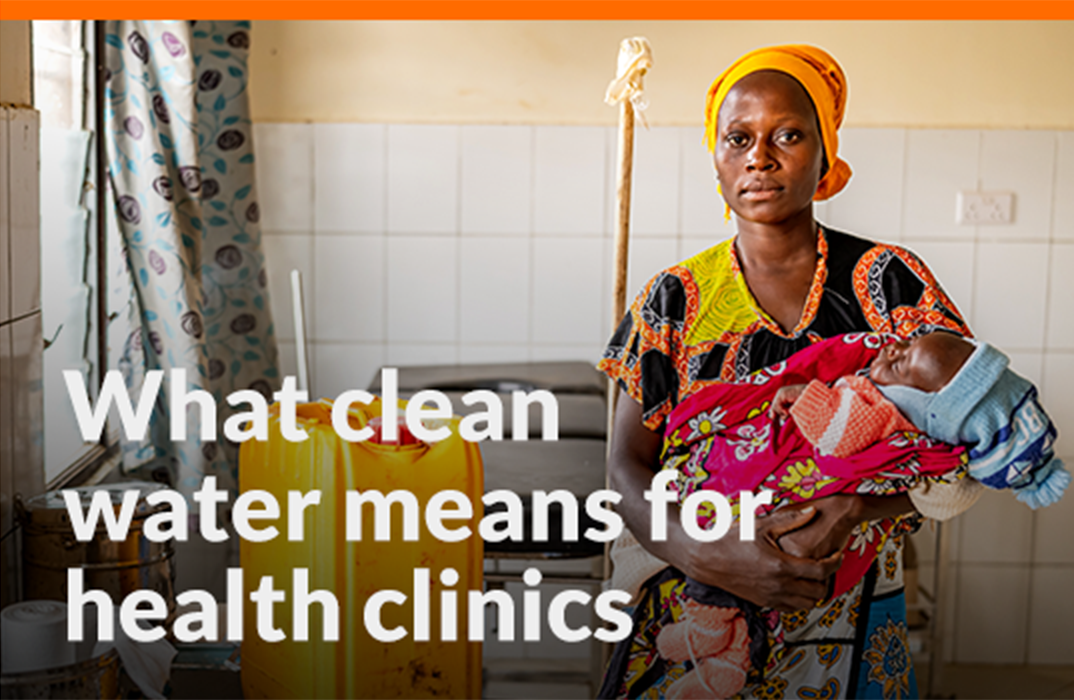 A woman holds a baby wrapped in blankets in a health clinic.