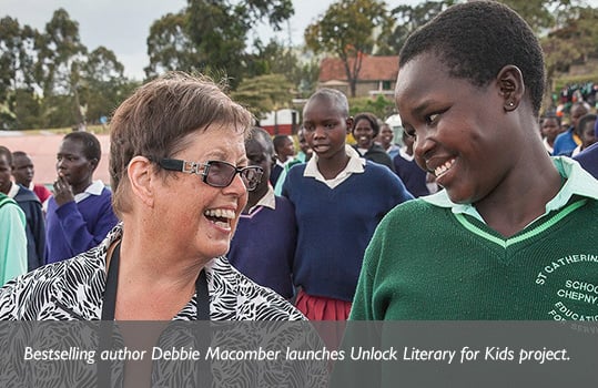 Author Debbie Macomber and a young Rwandan woman in a school uniform look at each other and share a smile