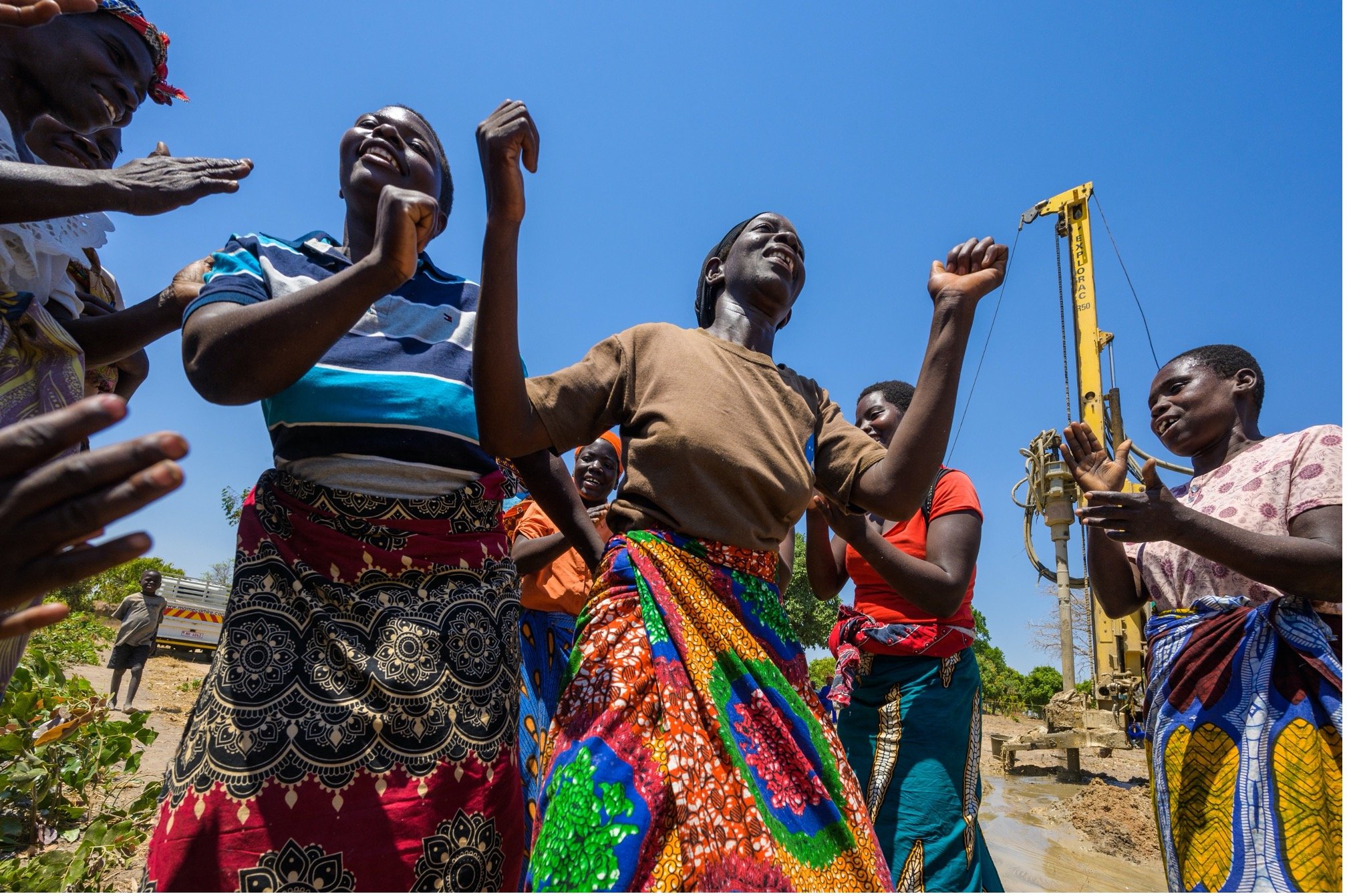 Women celebrating a borehole bringing clean water to their community in Mpondagaga, Malawi. (©2019 World Vision/photo by Jon Warren)