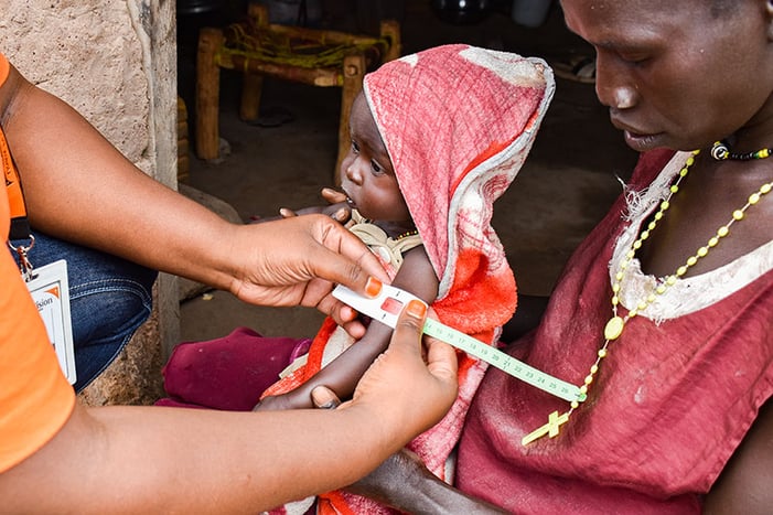 A mother in South Sudan lost a child to malnutrition and now she holds her surviving daughter close.