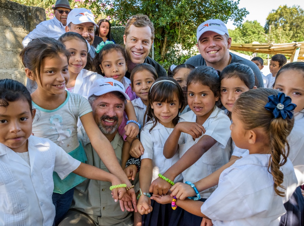 Children from a school which received clean water through RTI funding show off handmade bracelets they received from the team.