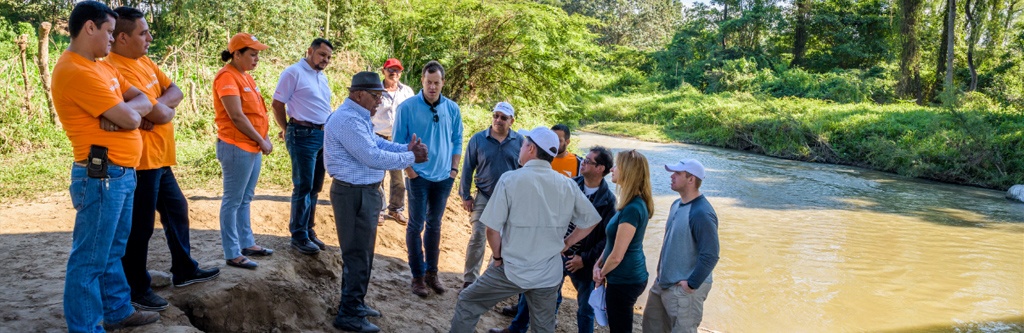 Cody and the RTI team seeing first hand the dirty water that the Jamastran community used to drink from before they received their new water system.