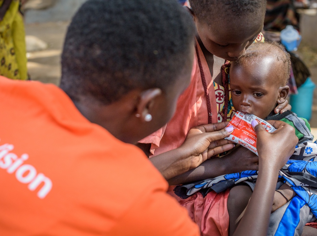 World Vision staff nutritionist, June Cherutich gives baby Akusi, 9 months, Ready to Use Therapeutic Food (RUTF) after finding that she is severely malnourished. 