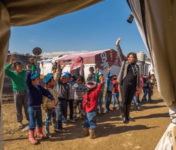 Syrian refugee teacher, Wafaa, (a former public school teacher) and her class play a game of follow the leader at World Vision’s Early Childhood Education program in Lebanon.